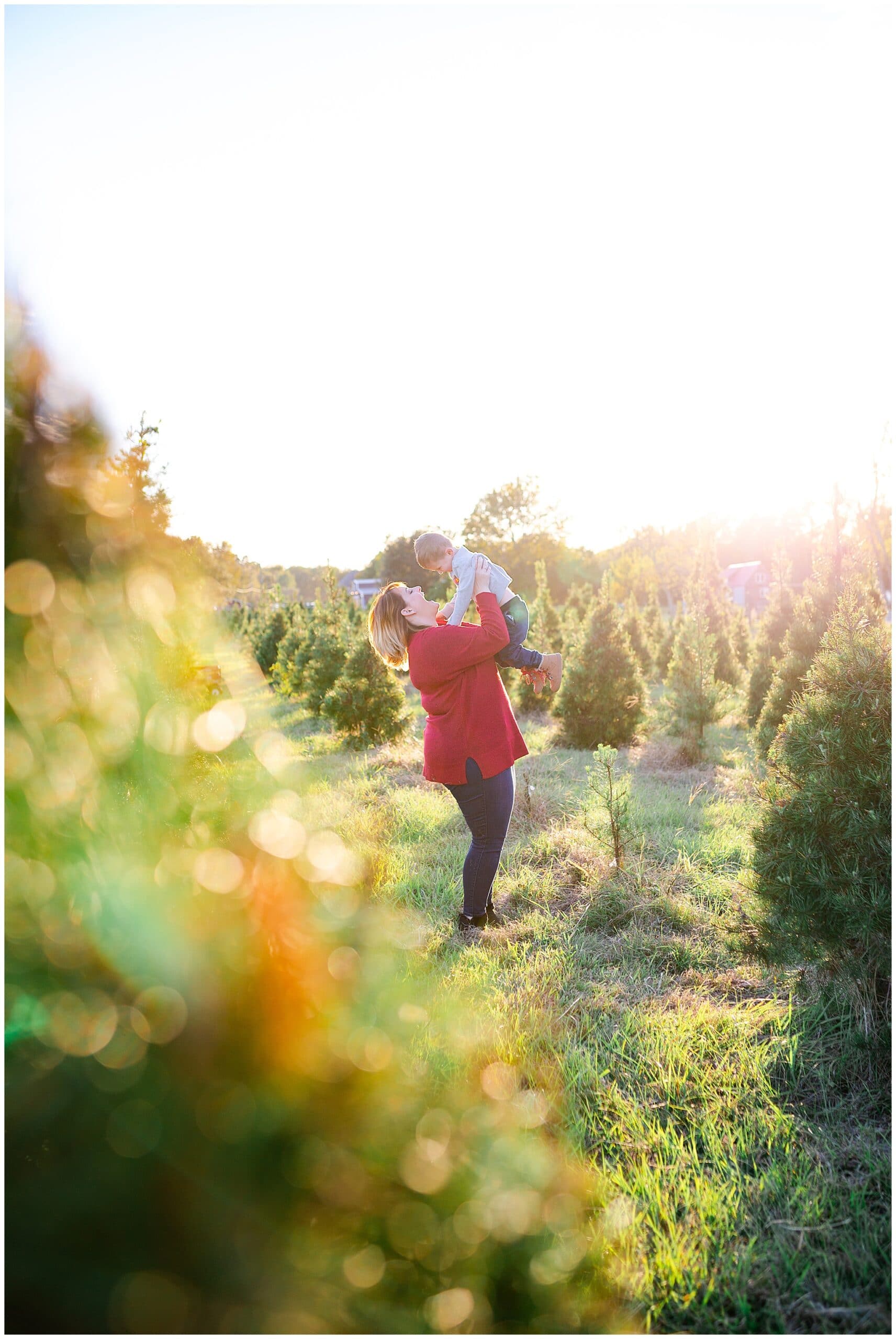 mom and son posing at Christmas tree farm for family portraits by Swish and Click Photography at Holiday Acres Farm in Manvel Texas