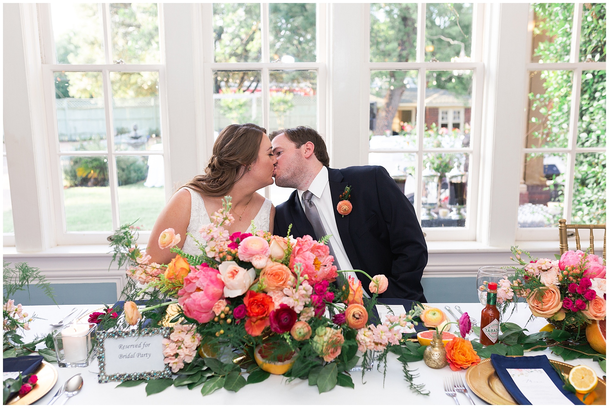 bride and groom kissing at their table at Astin Mansion in Bryan Texas by Swish and Click Photography