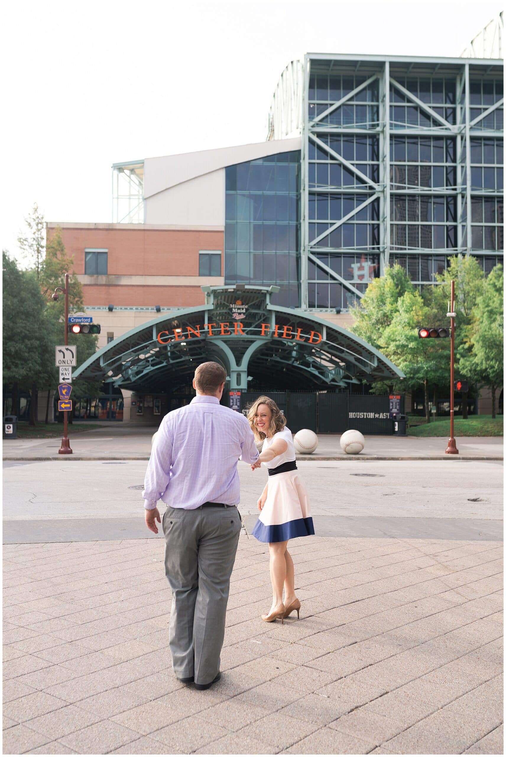 engaged couple walk outside Astors Minute Maid Park in downtown Houston by Swish and Click Photography