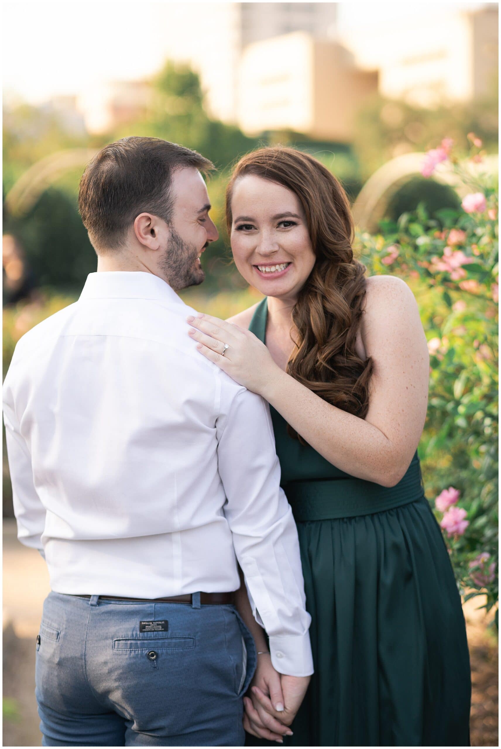 engaged couple snuggle during their engagement session at McGovern Centennial Gardens in Houston Texas captured by Swish and Click Photography