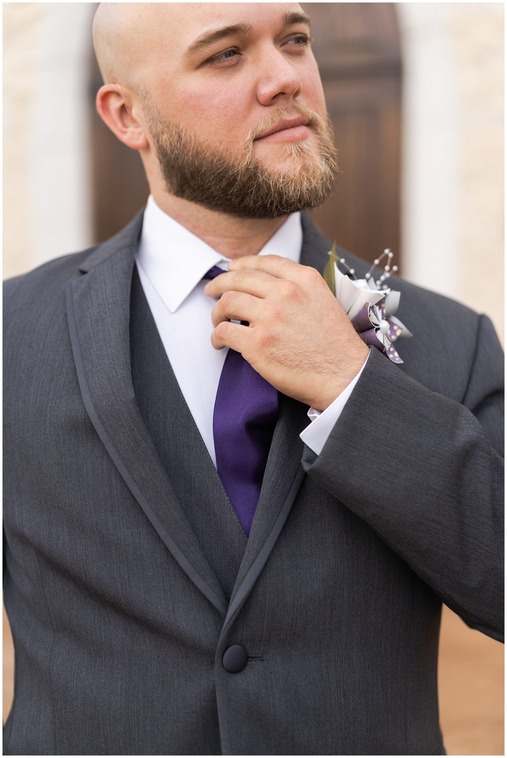 groom adjusts his tie on his wedding day at Ashton Gardens in Houston Texas by Swish and Click Photography