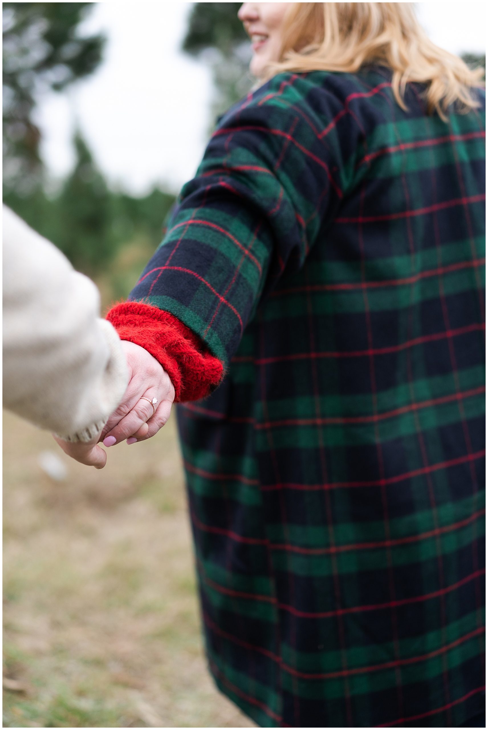 during their tree farm portrait session at Holiday Acres in Houston Texas by Swish and Click Photography couple hold hands as they walk