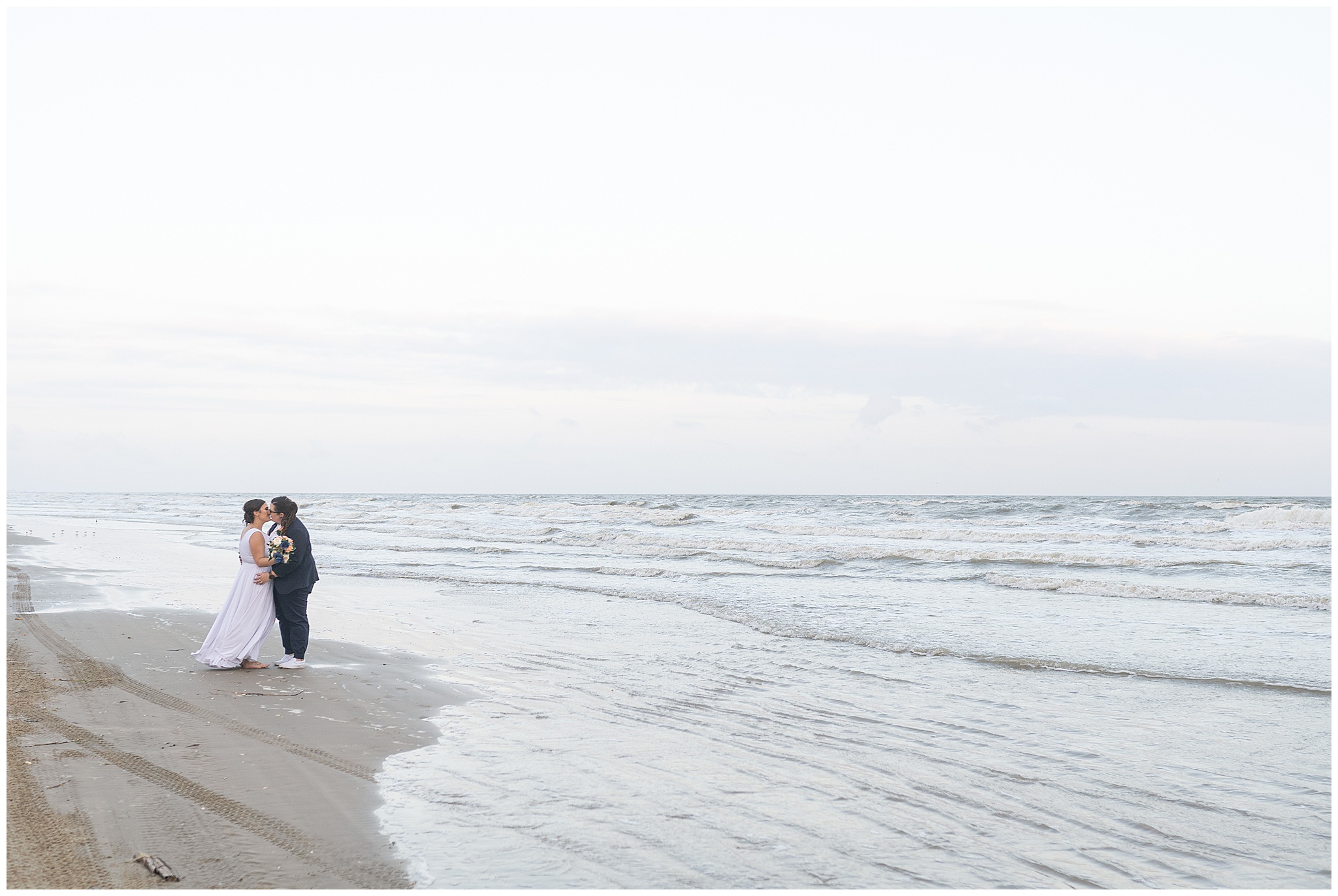 lesbian couples kisses on their wedding day on Galveston Beach by Swish and Click Photography