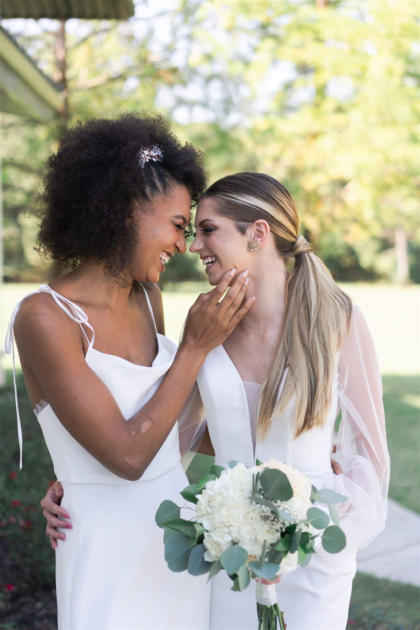 lesbian couple laugh with each other on their wedding day captured at 15 acres wedding venue by Swish and Click Photography in Houston Texas