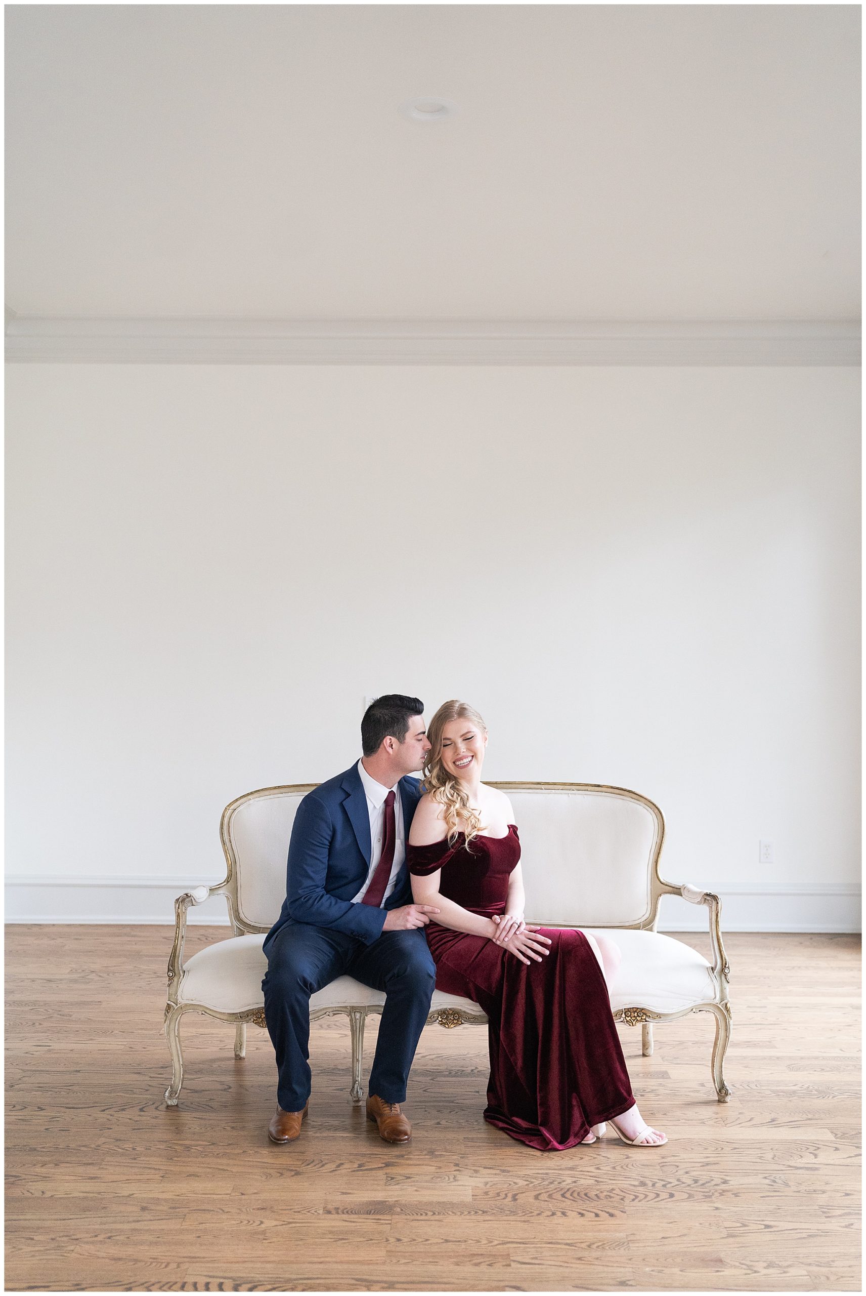 couple cuddle on a couch during their engagement session at the Creative Chateau in Houston by Swish and Click Photography