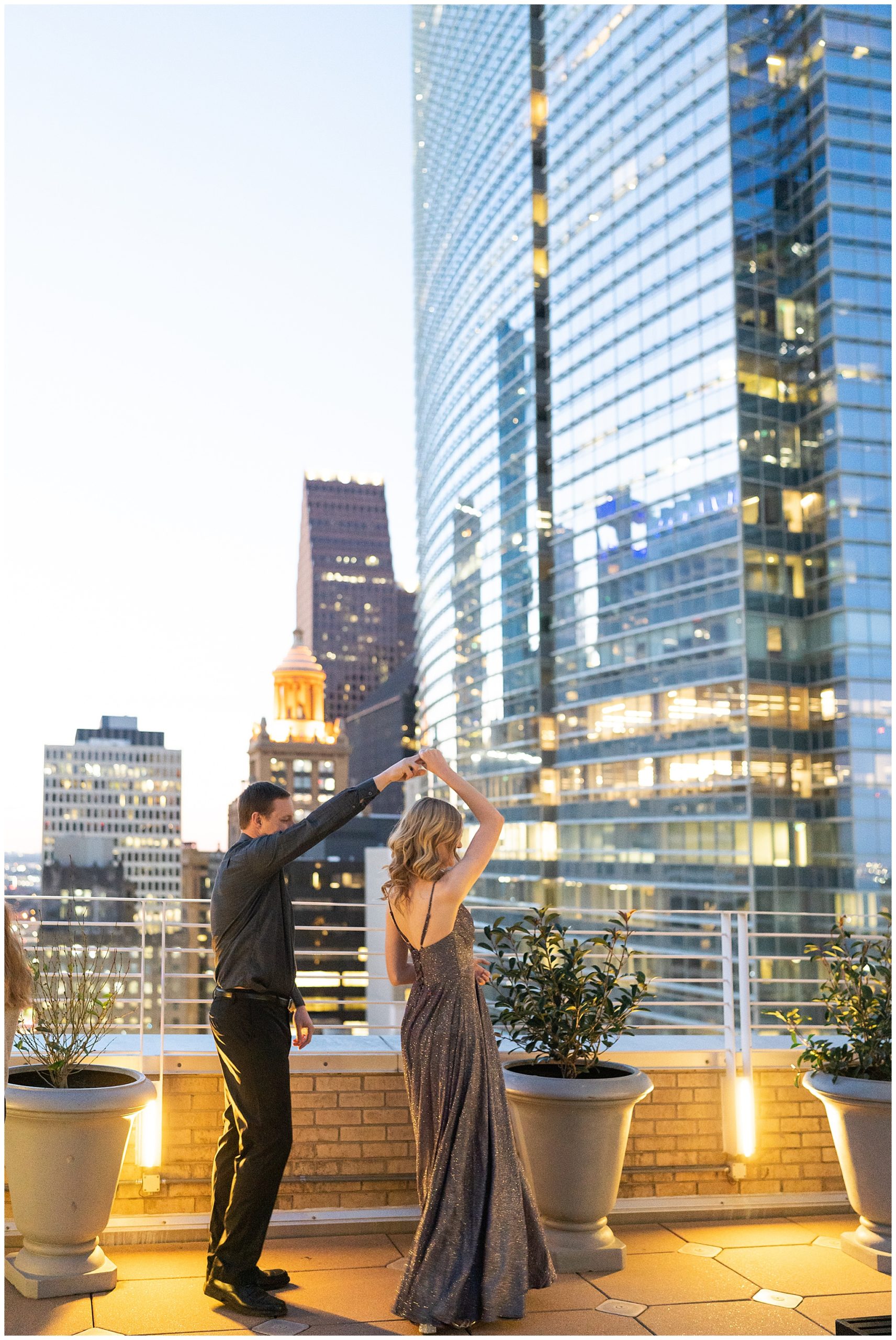 engaged couple dance on a rooftop in downtown Houston during their engagement session by Houston's best wedding photographers Swish and Click Photography