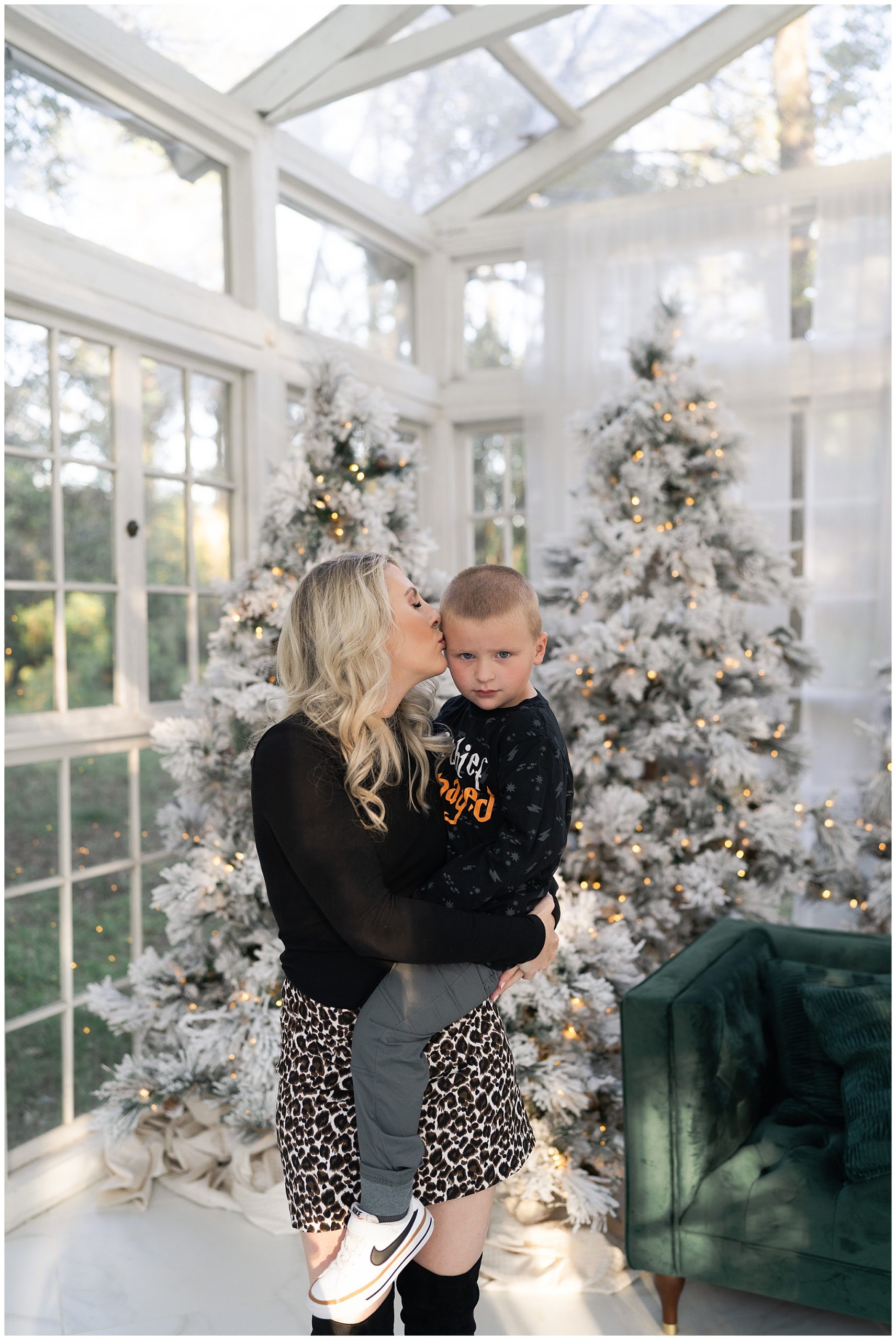 mom kisses her son during Christmas photos at the Oak Atelier in Houston Texas by photographer Swish and Click Photography