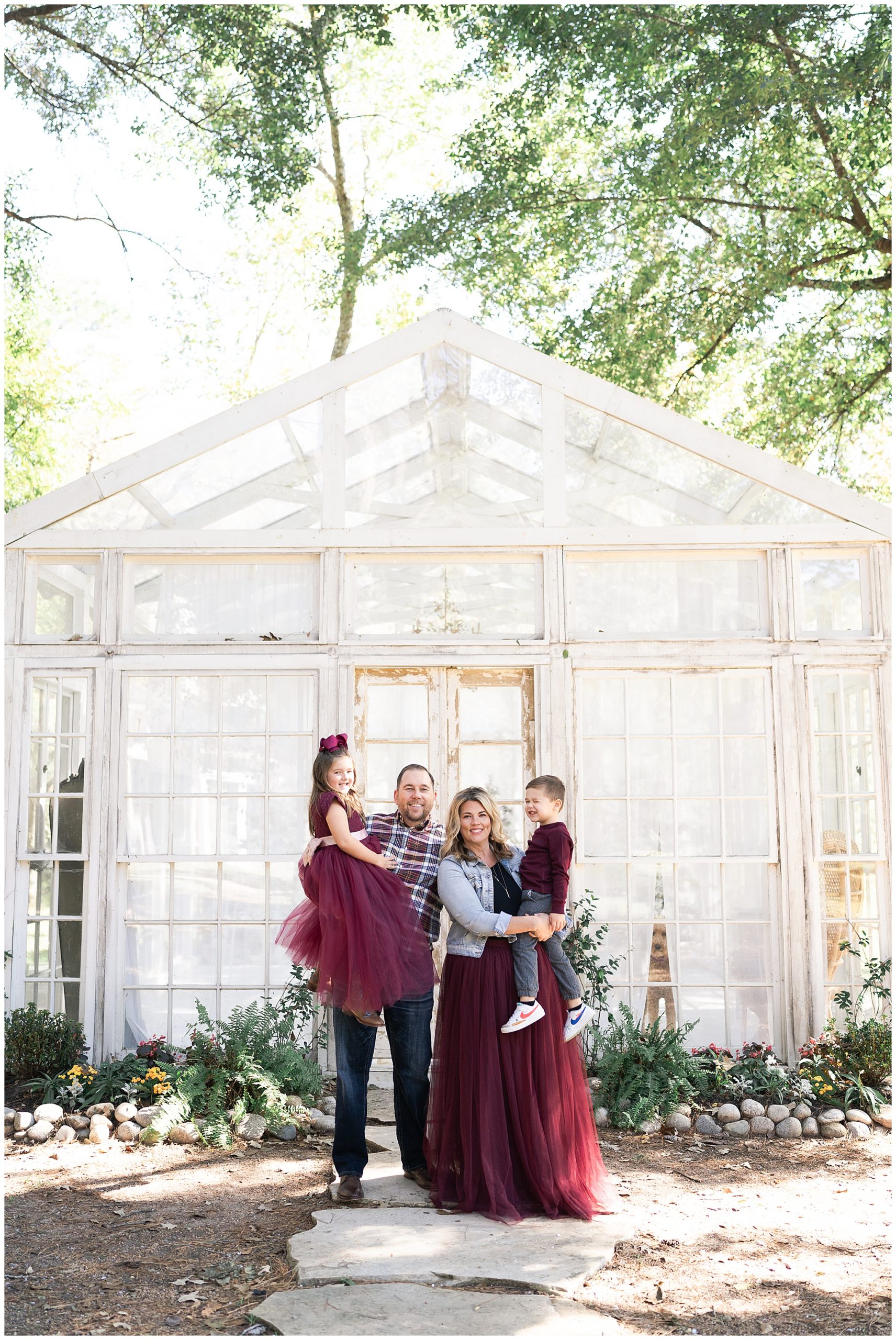 family poses for photos at a greenhouse in Houston Texas by photographer Swish and Click Photography