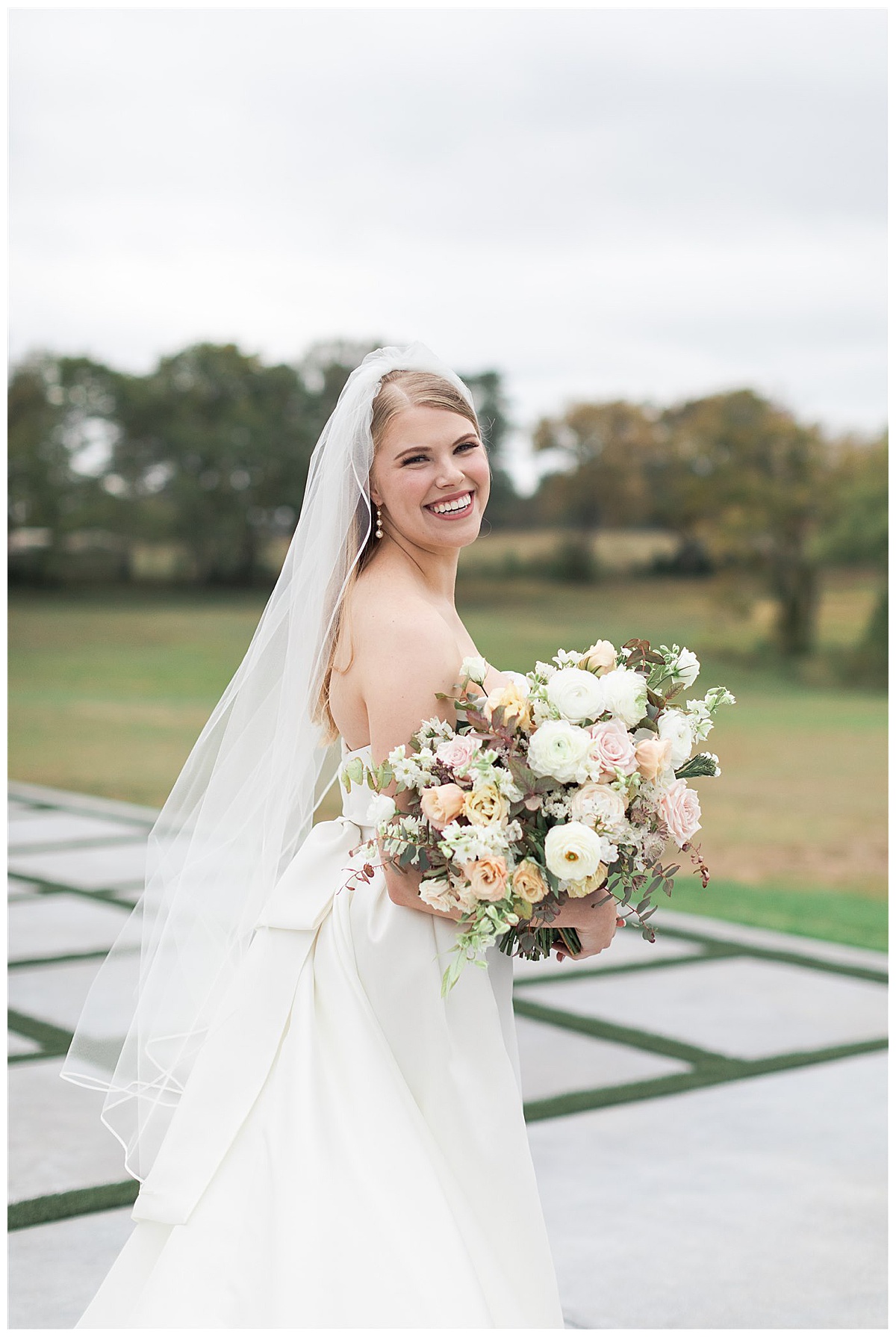 Bride smiles big with beautiful bouquet at The Homestead