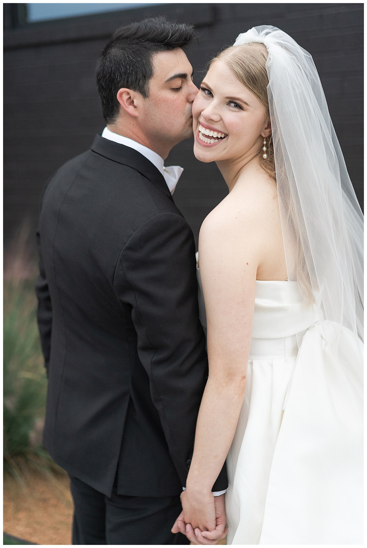 Man kisses woman on cheek as she smiles big for Swish & Click Photography