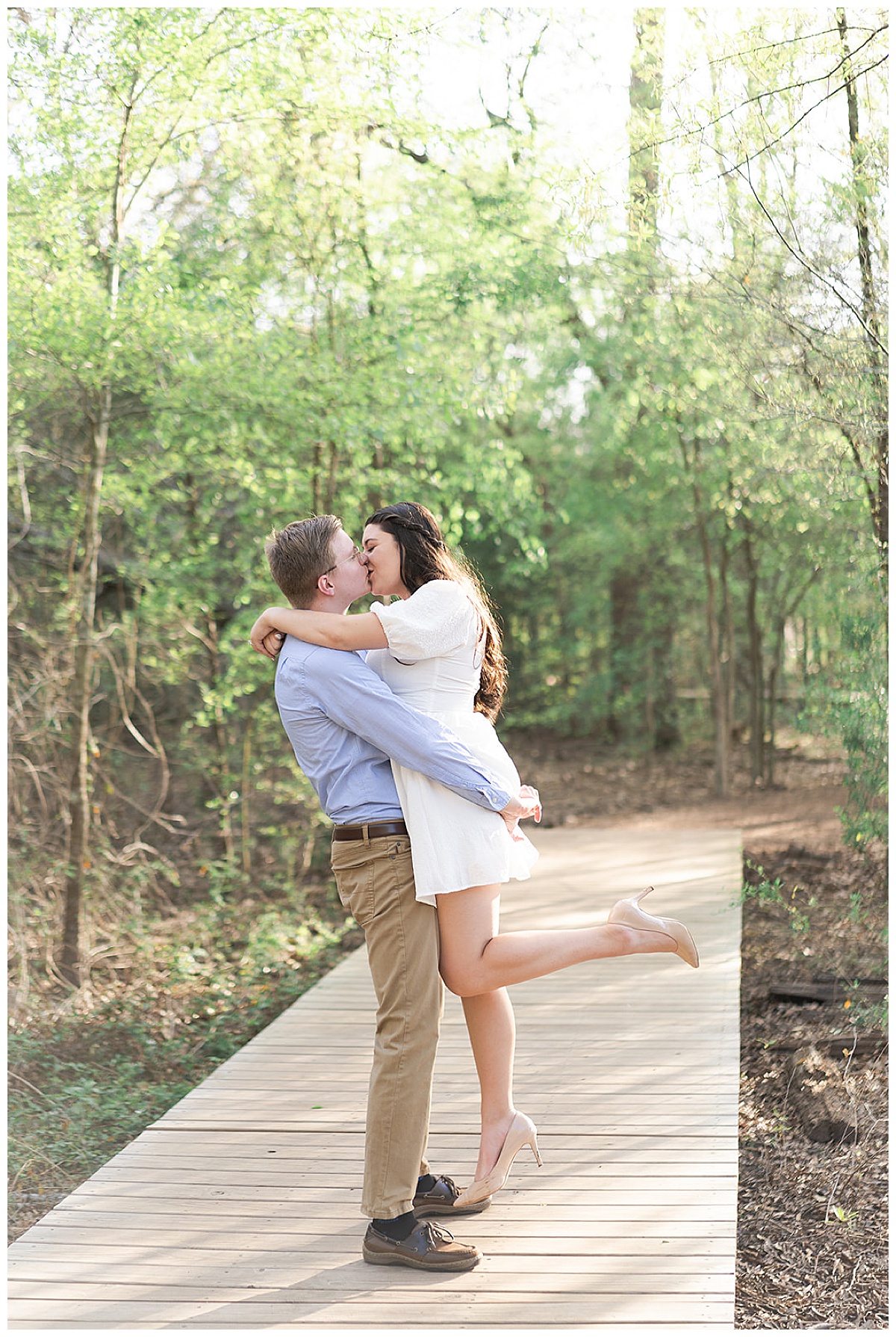 Woman kisses man and dance together during Houston Arboretum Engagement Session