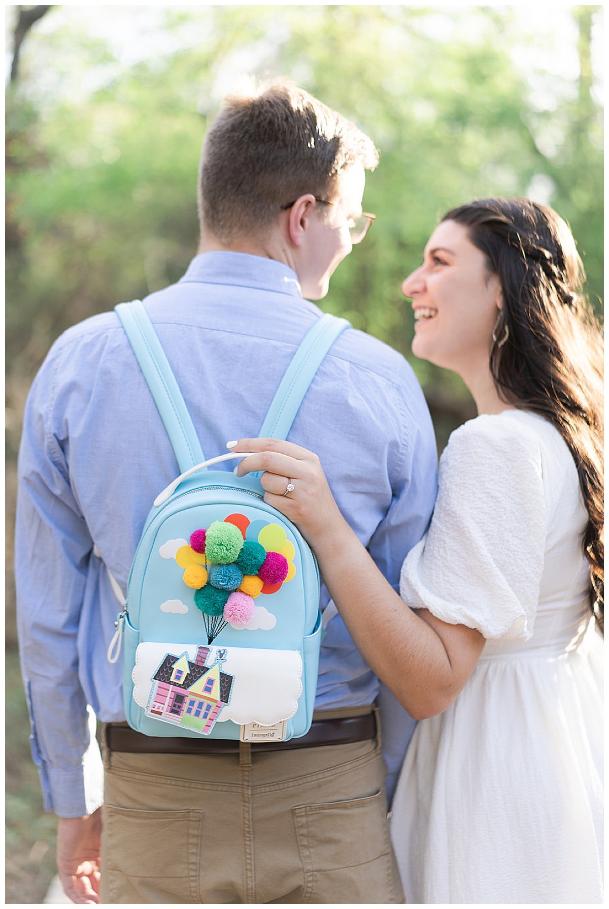 Man and woman smile with Disney backpack for Houston’s Best Wedding Photographers