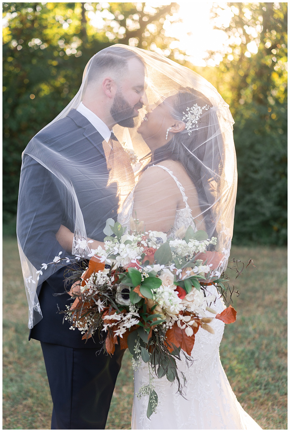 Couple smile together under veil at The Bowery House & Gardens