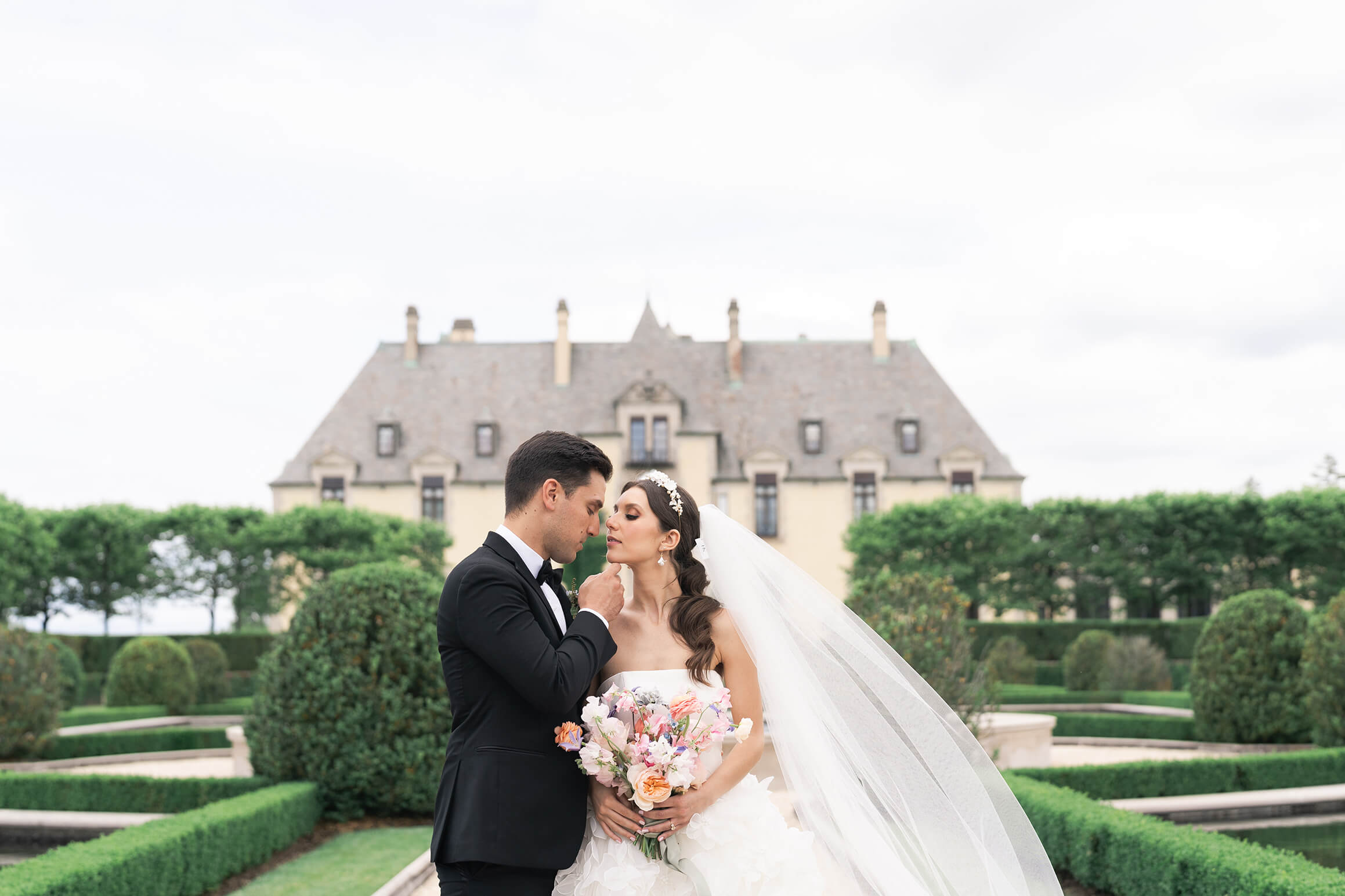 wedding couple kiss in the garden of Oheka Castle by Toronto's best wedding photographers Swish and Click Photography