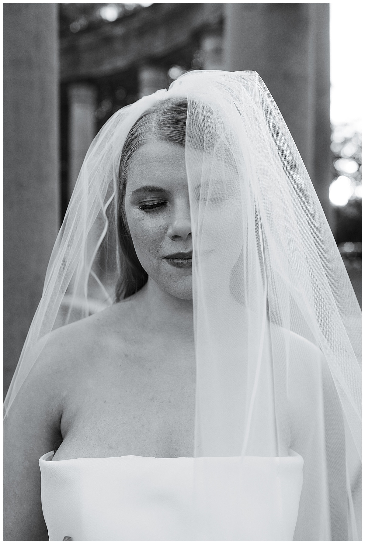 Gorgeous bride smiles down with veil over face for Swish & Click Photography