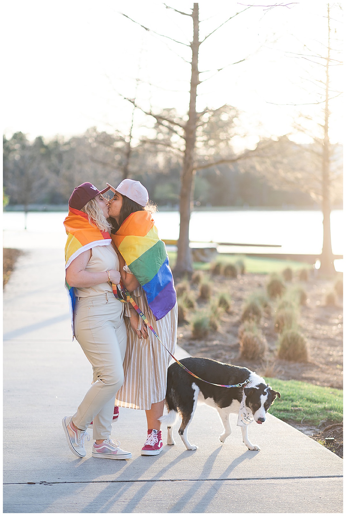 Two women share a kiss wrapped in a Pride flag for Swish & Click Photography
