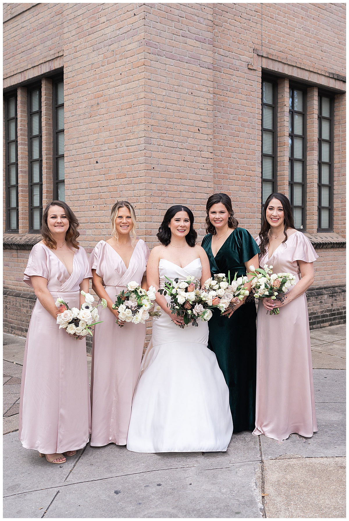 The bride stands bridesmaids for Swish & Click Photography