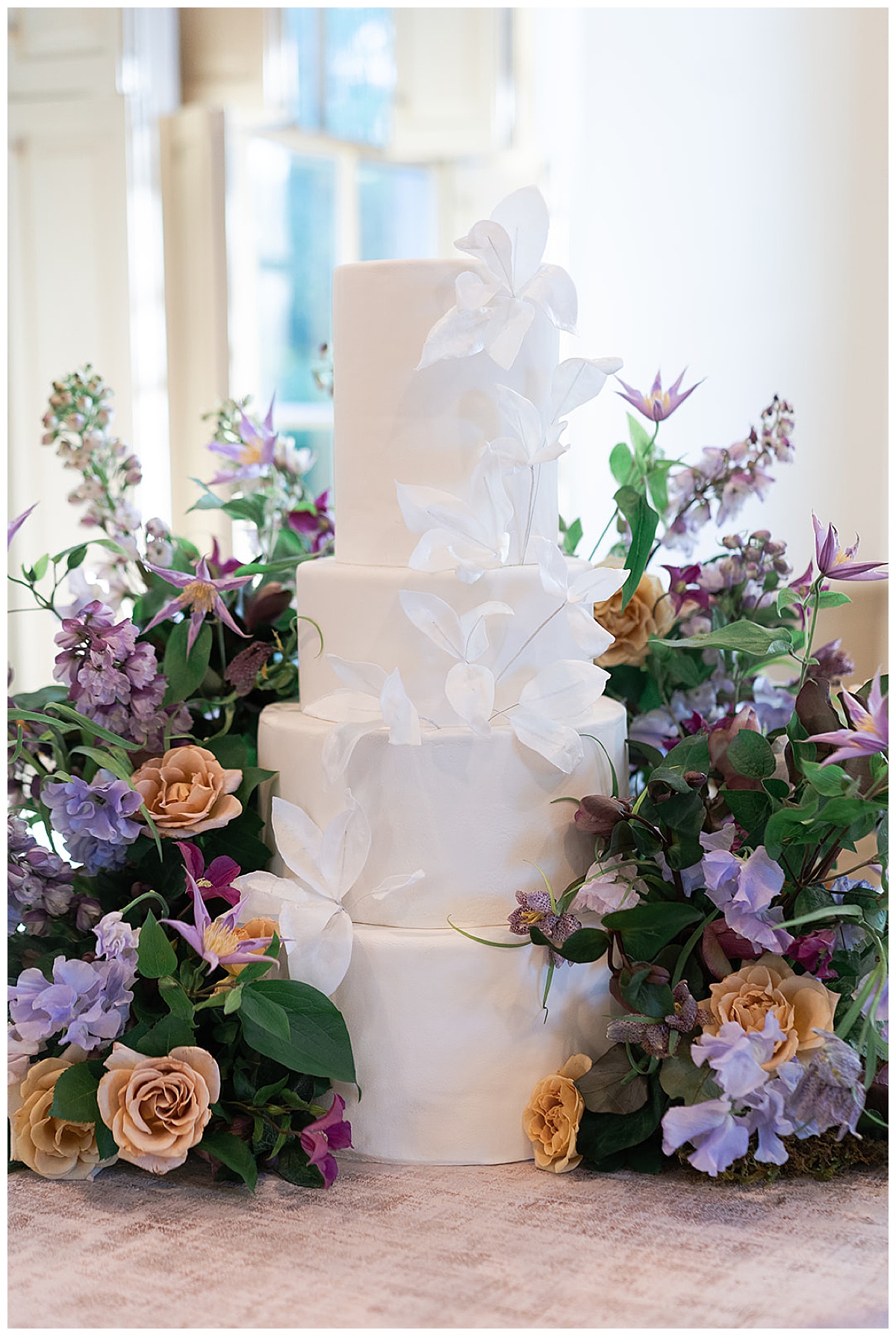 White cake surrounded by stunning florals for Swish & Click Photography