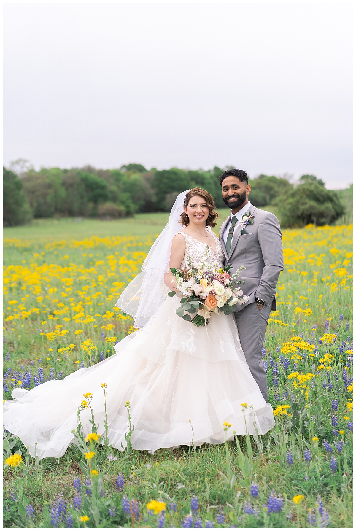 Husband and wife stand in wildflower field for Swish & Click Photography