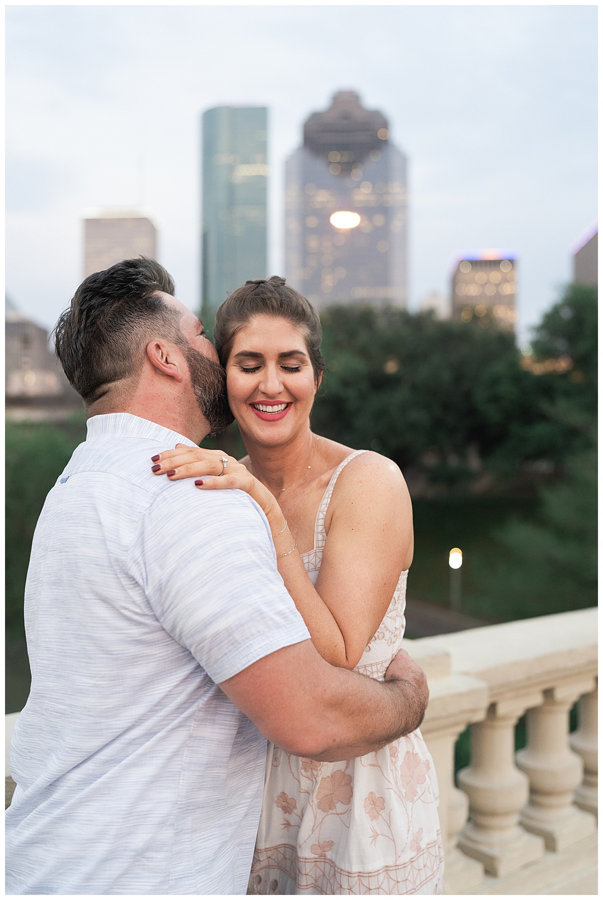 Man and woman share a kiss for Downtown Houston Engagement Session