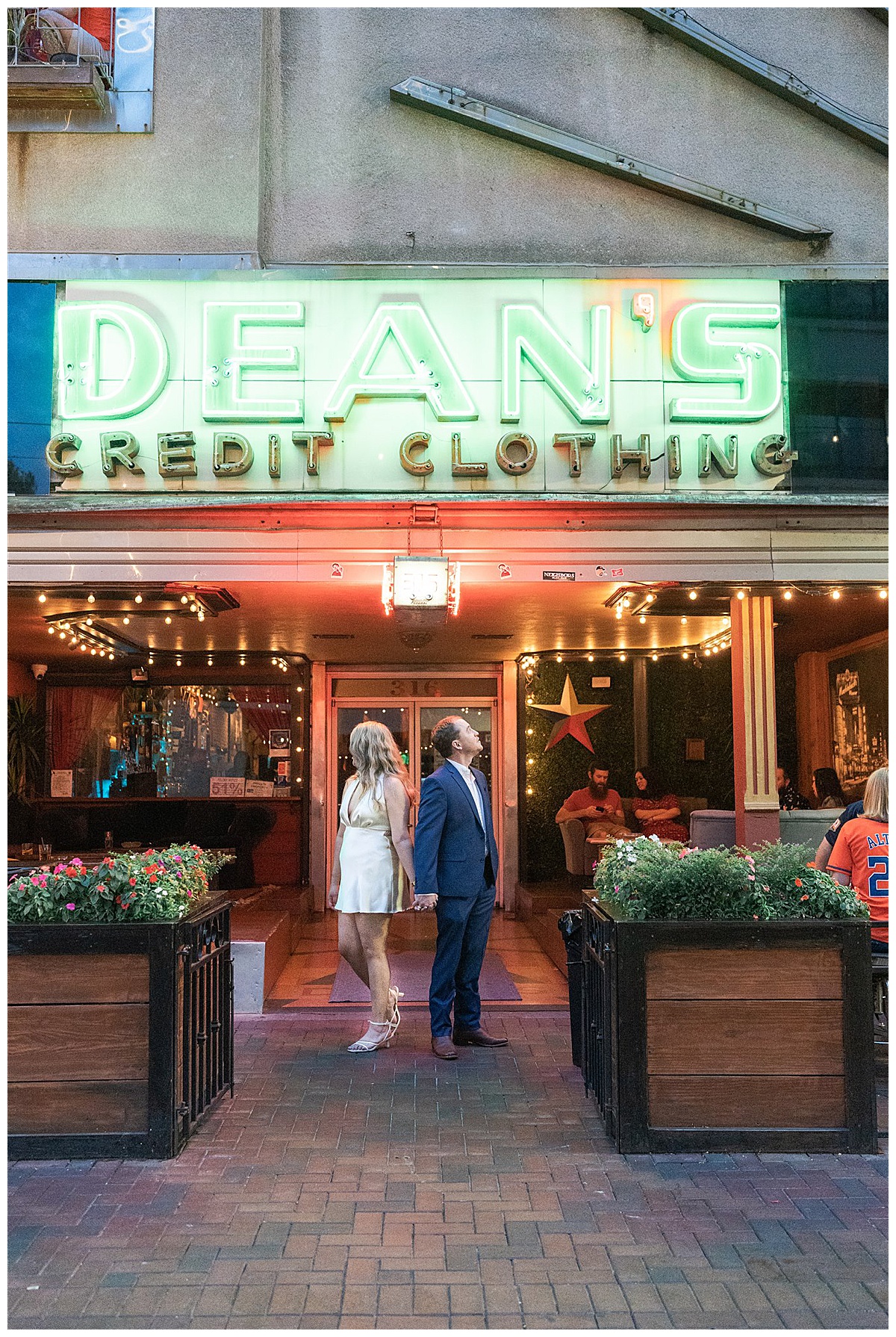 Couple stand facing away from one another in front of restaurant for Modern Houston Engagement Session