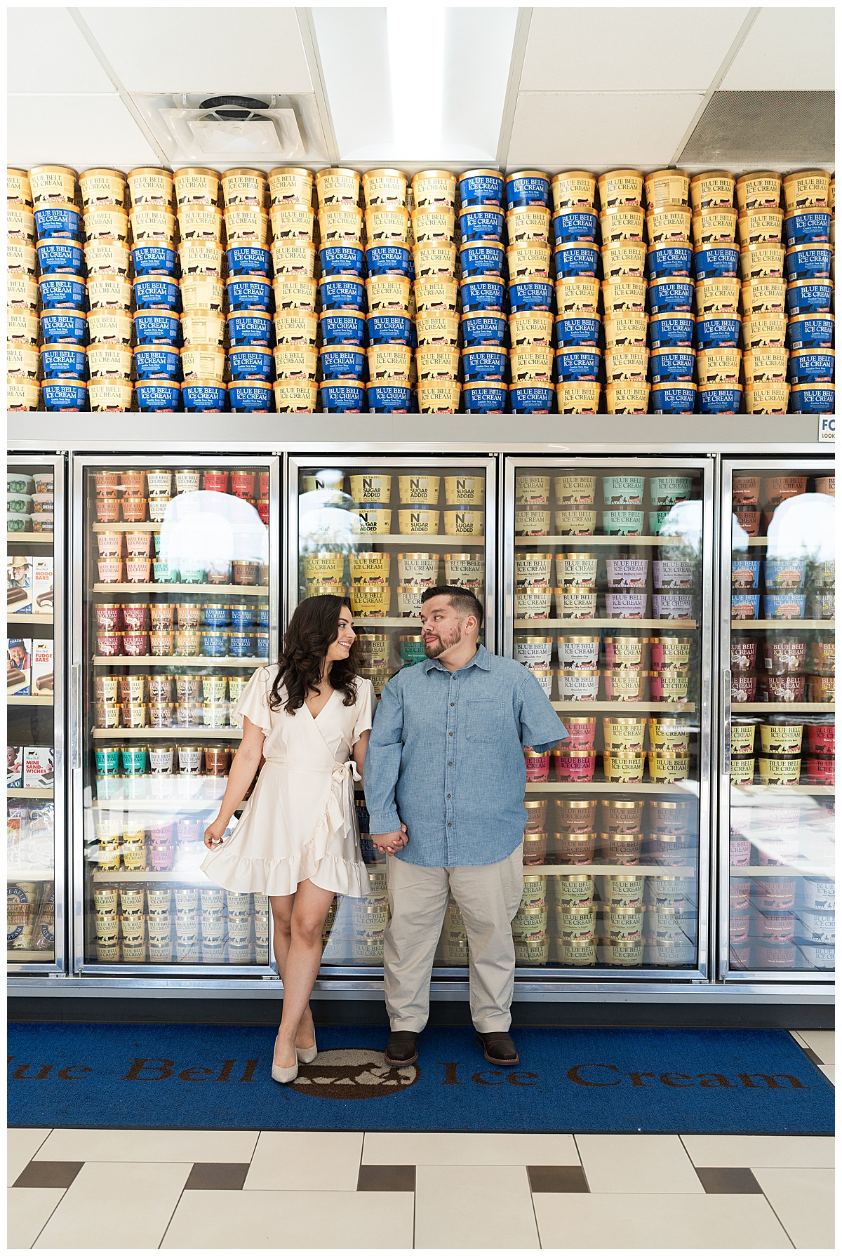 Two people share a smile in front of Blue Bell ice cream freezer for Swish & Click Photography