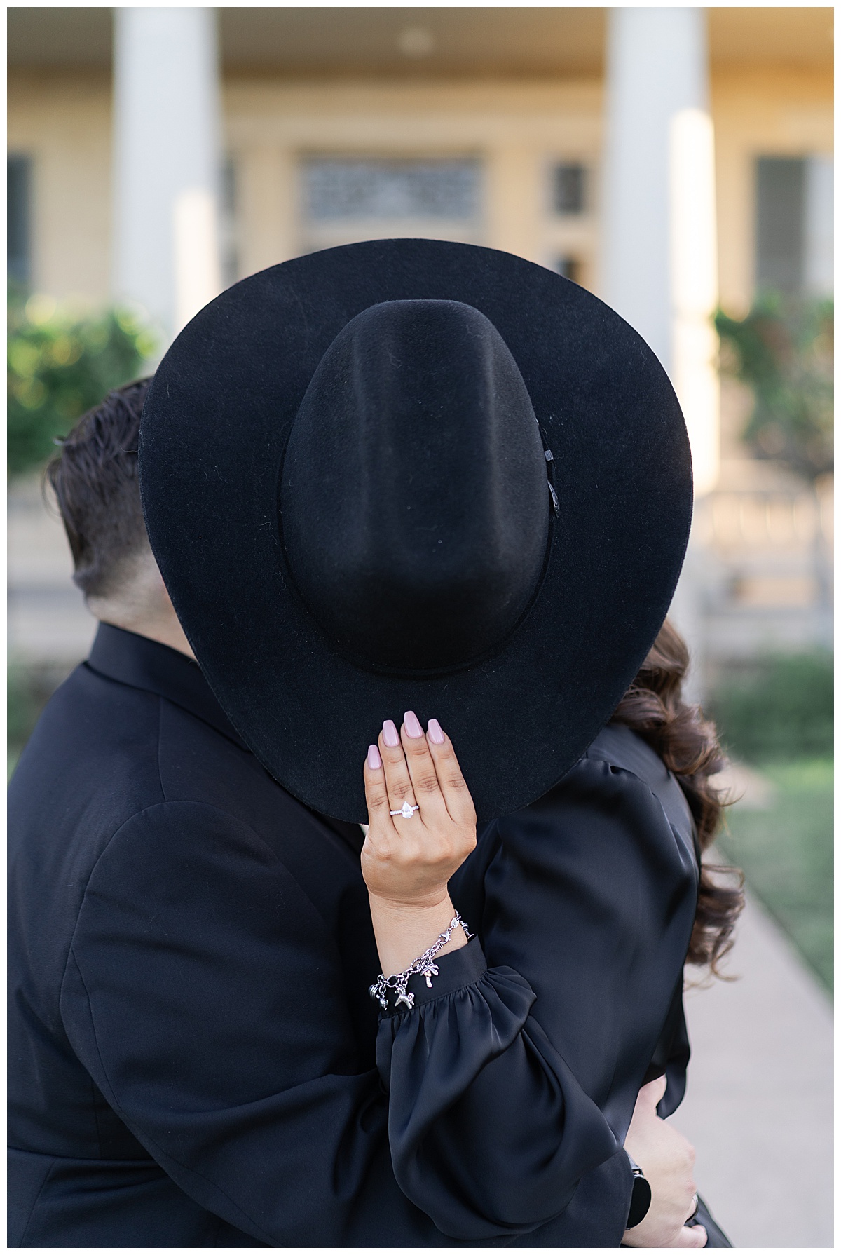Woman holds hat in front of couple for Houston’s Best Wedding Photographers