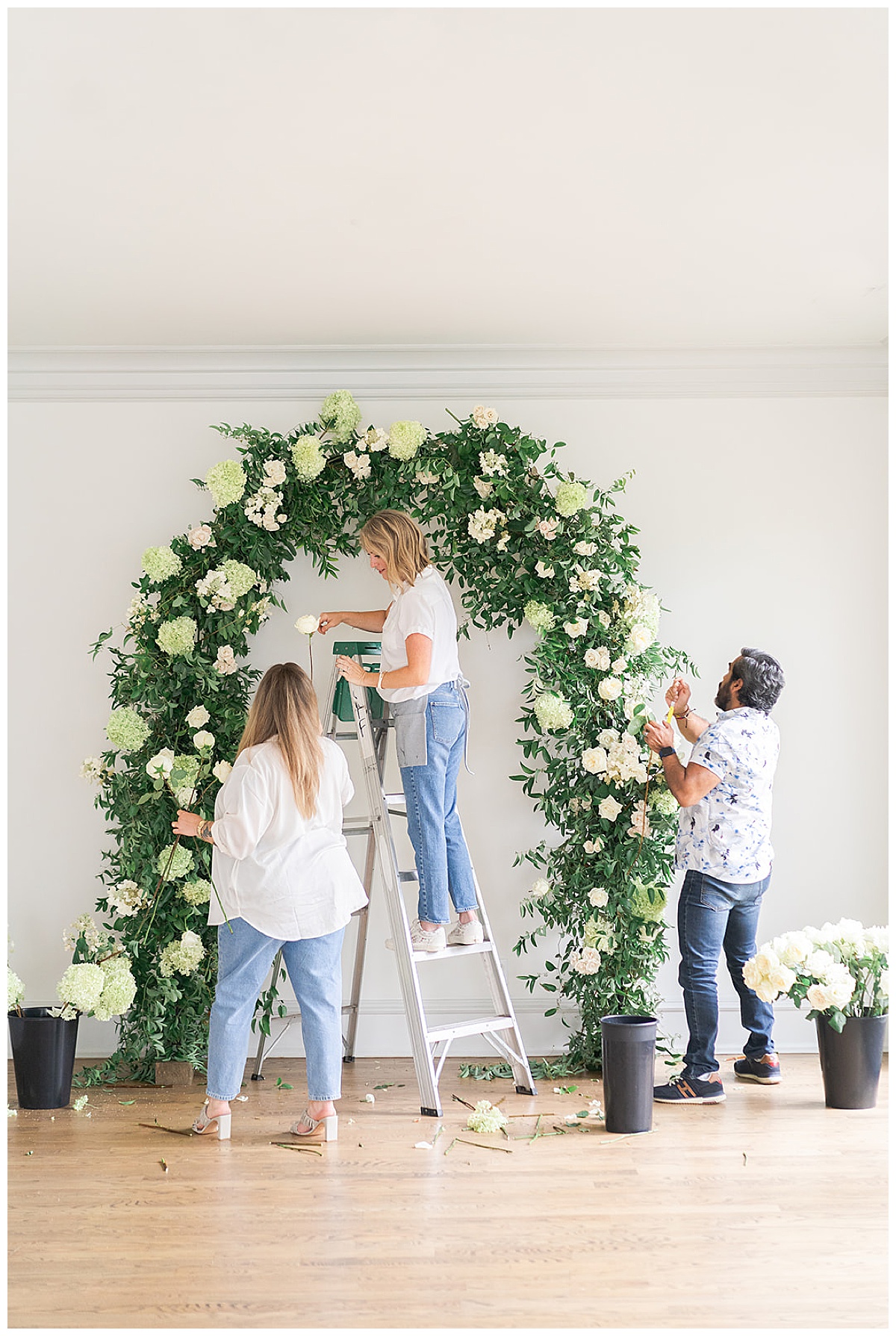 People install a floral arch for Swish & Click Photography