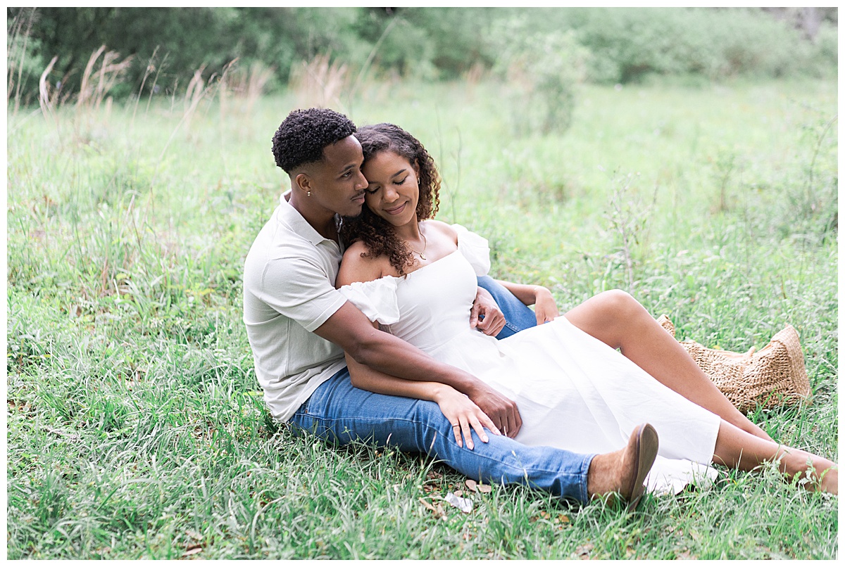 Two people sit in the grass together for Swish & Click Photography