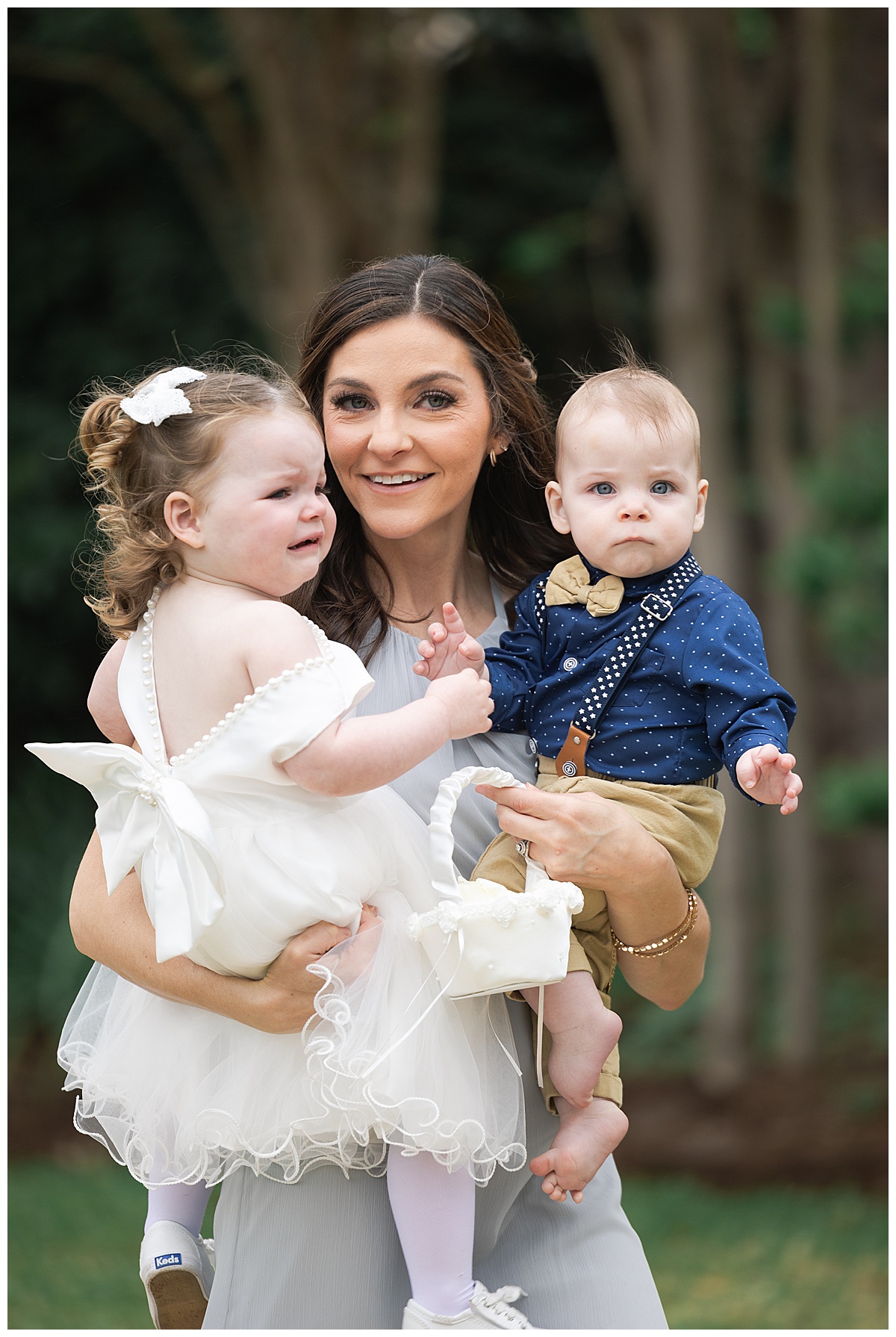 Woman holds two kids who are not at an Adult-Only Wedding