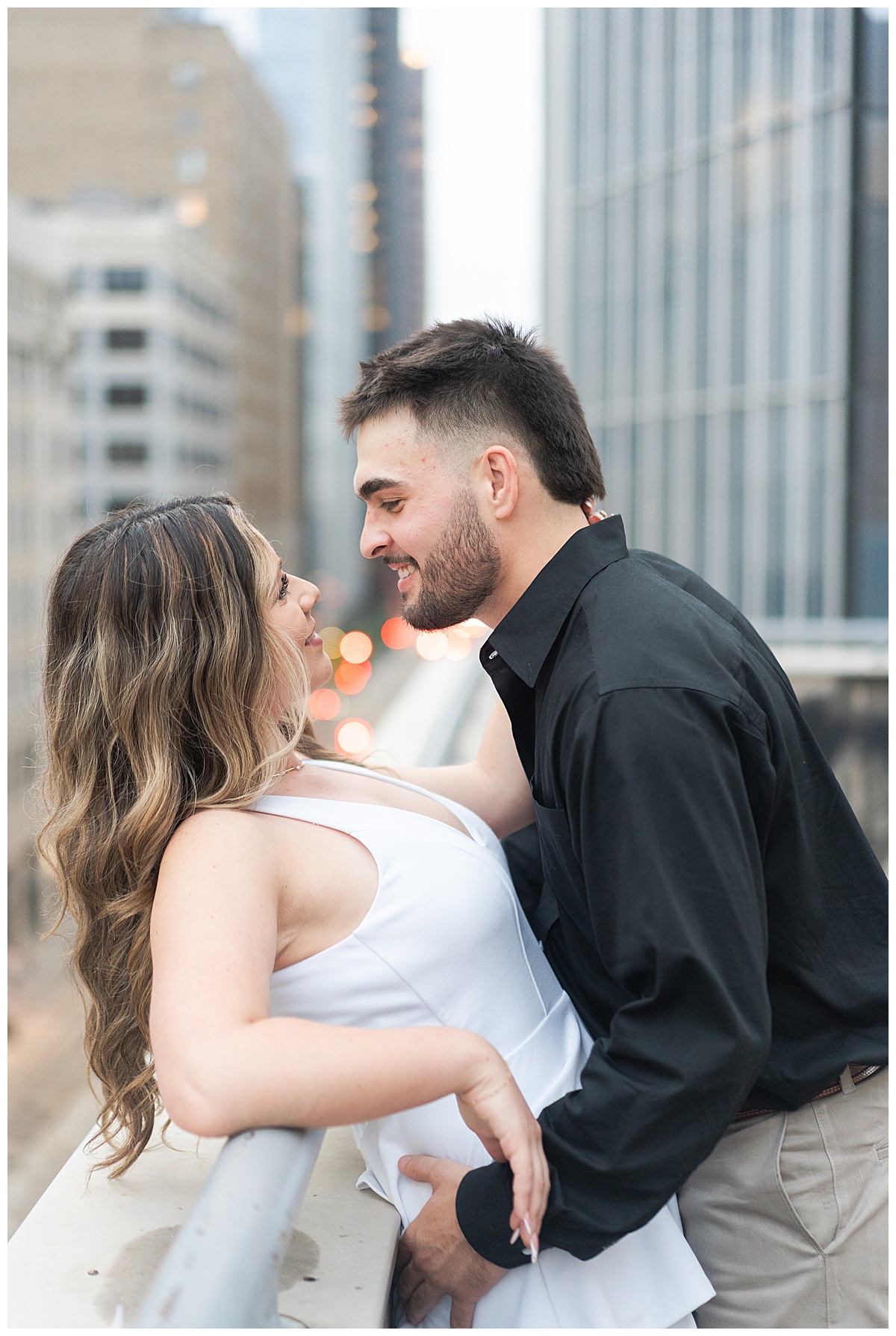 Couple smile together on the rooftop showing one of the Best Engagement Photo Locations in Houston