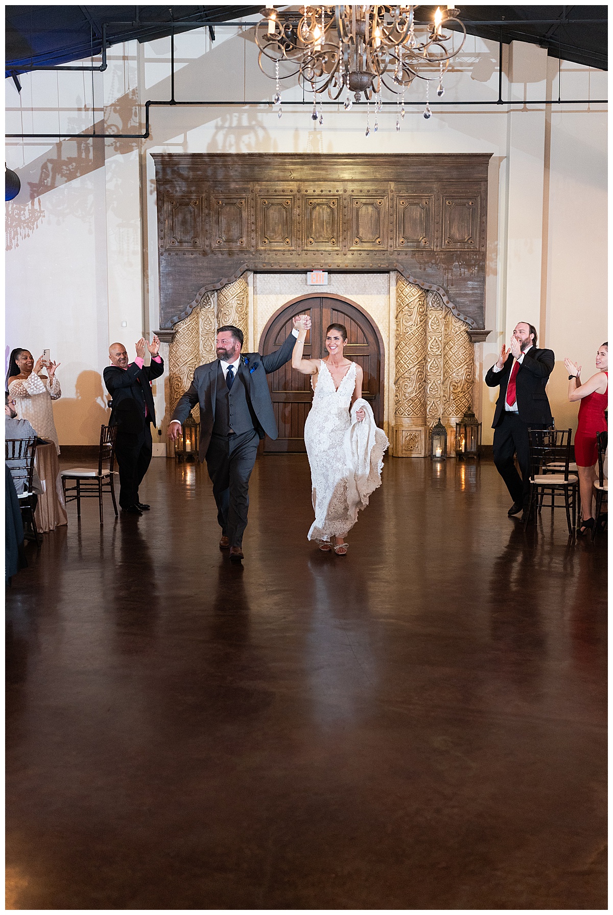 Couple enter their reception with smiles by Madera Estates Wedding Photographer