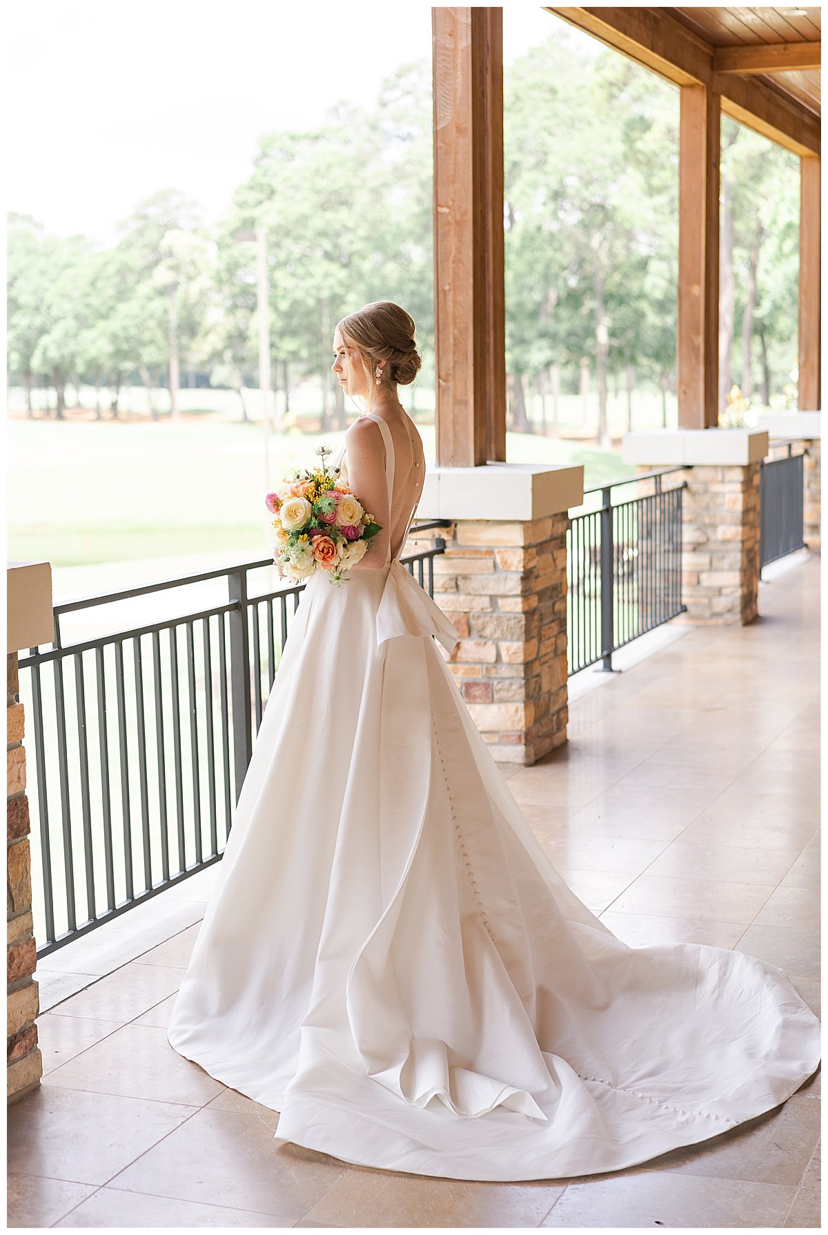 Woman wears wedding gown and looks out balcony at The Woodlands Country Club