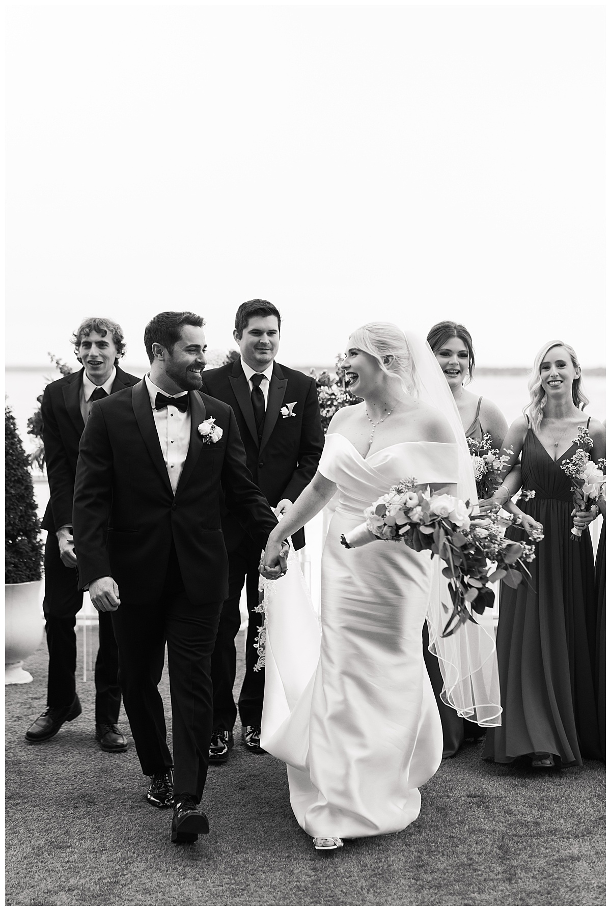 Bride and groom walk together holding hands by Swish & Click Photography