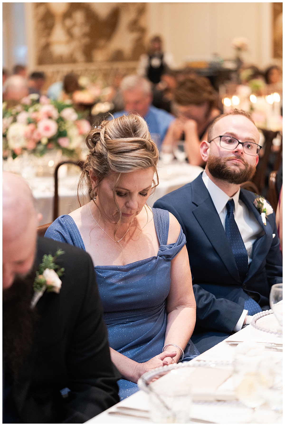 Mother of the groom bowing her head to pray at the reception captured by Swish and Click Photography