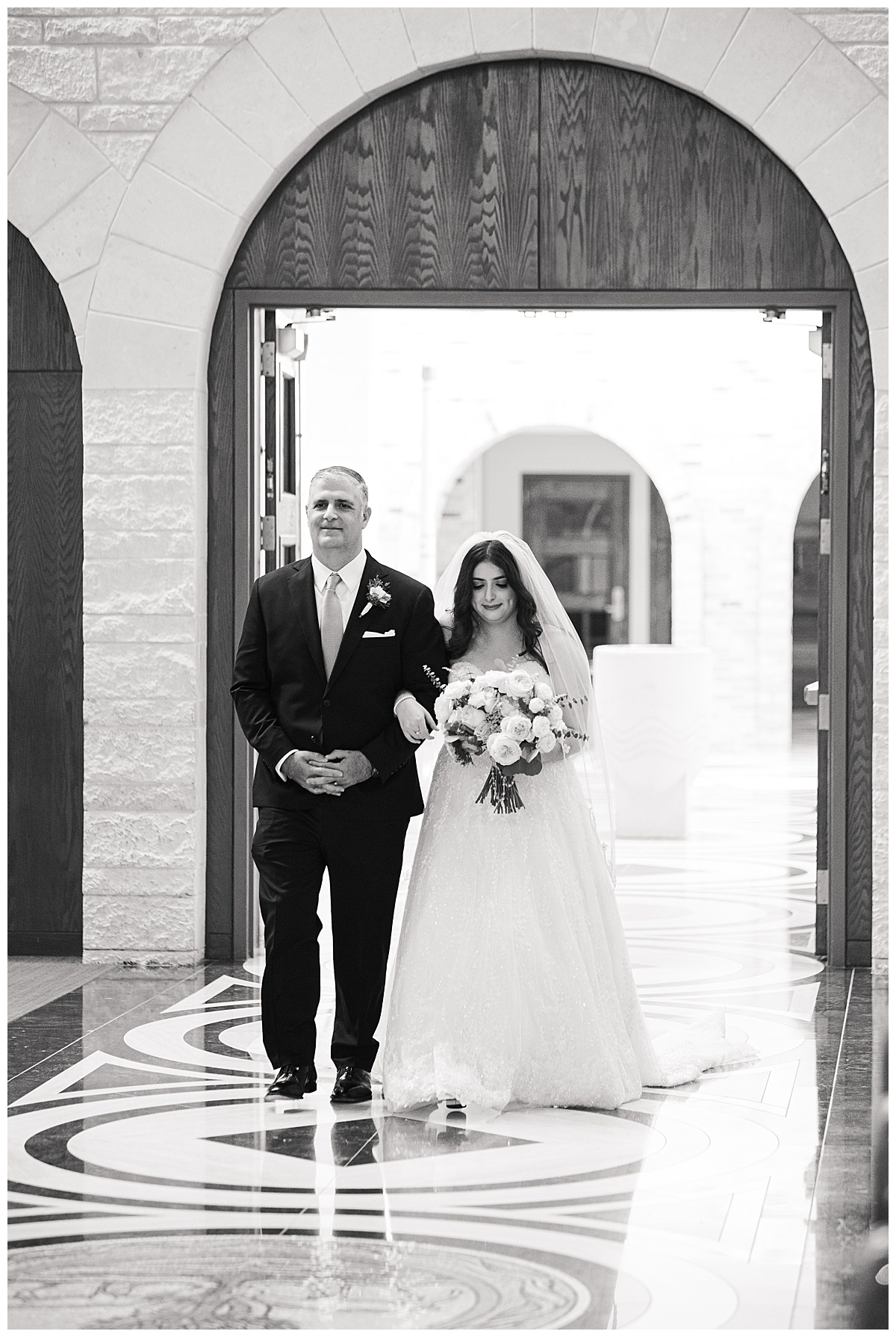 Father of the bride walking his daughter down the aisle in black and white captured by Swish and Click Photography