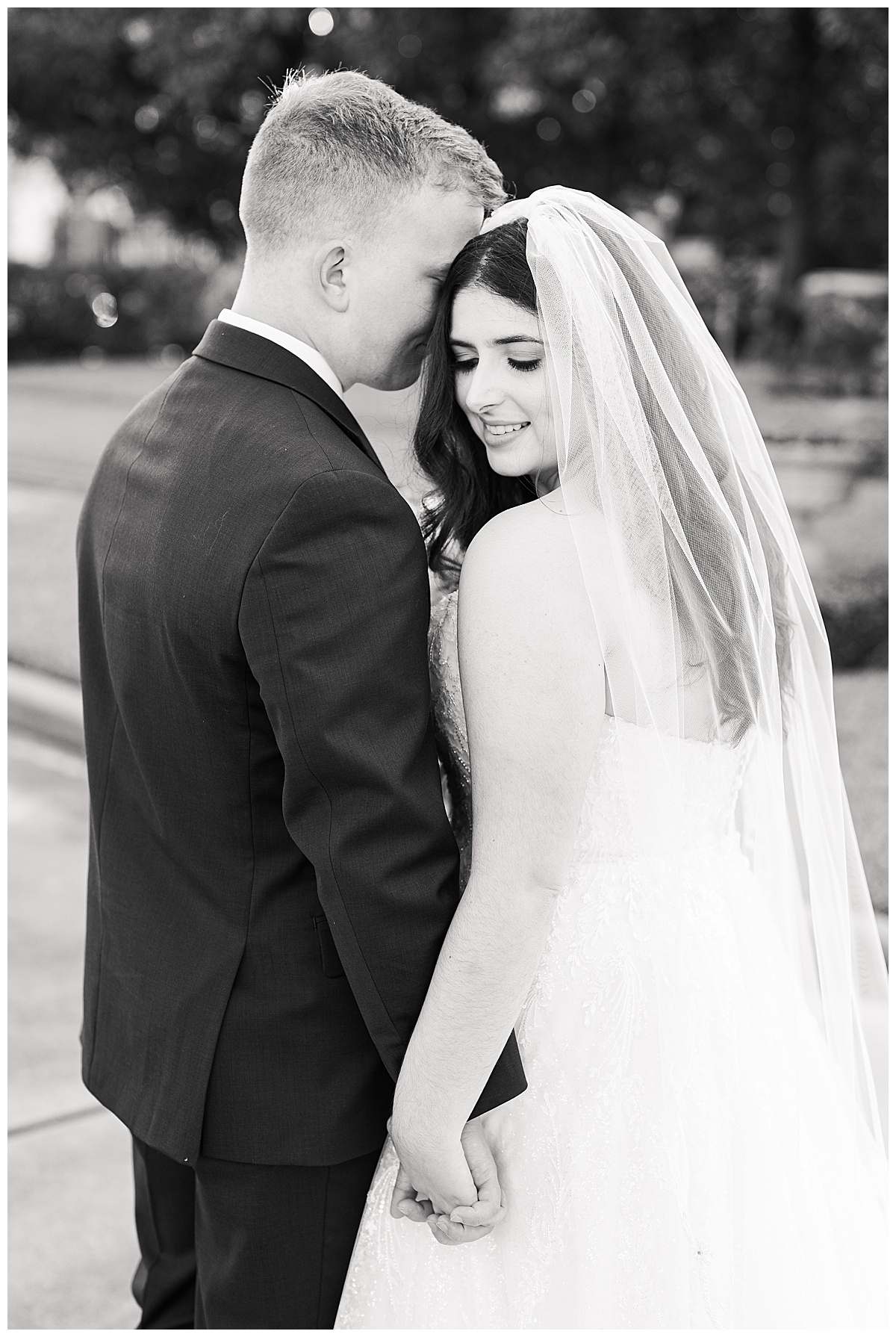 Black and white image of bride and groom sharing an intimate moment after the wedding photographed by Swish & Click Photography