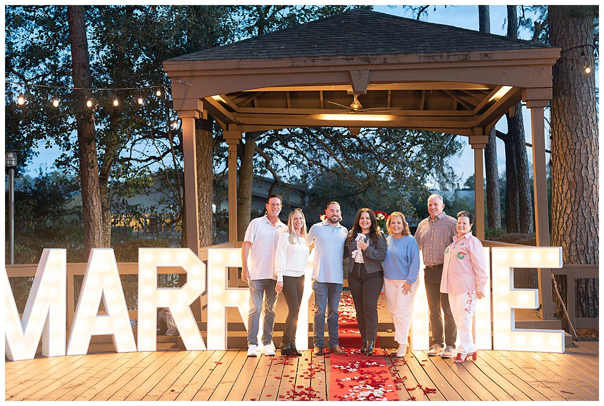 The family of the newly engaged couple take a celebratory photo.