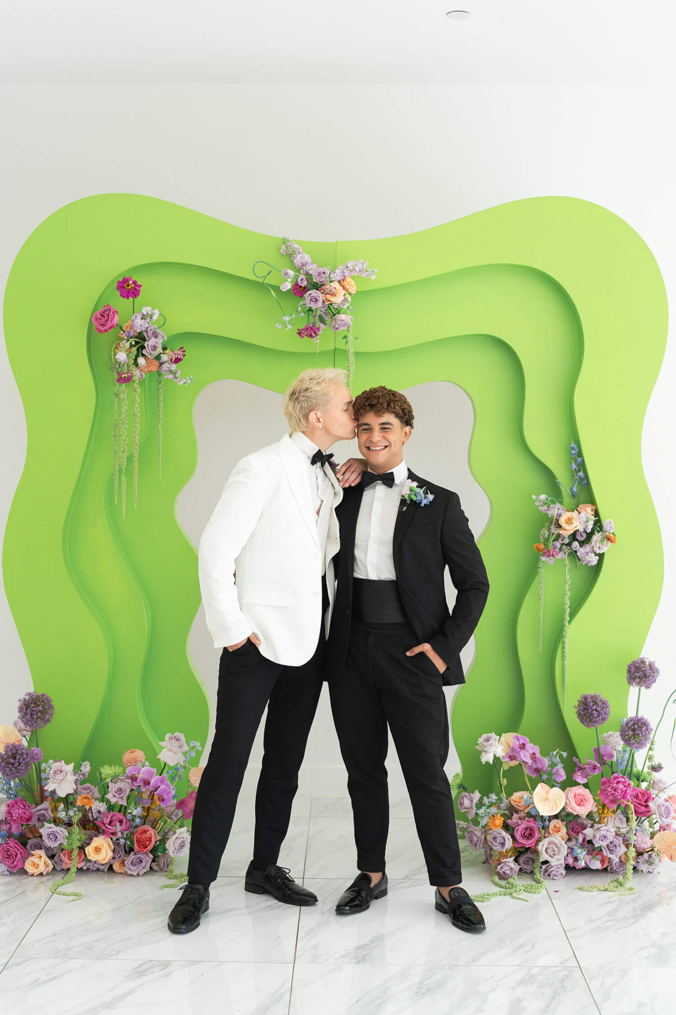 gay couple kiss in front a chartreuse arch on their wedding day at the Homestead venue in Houston Texas