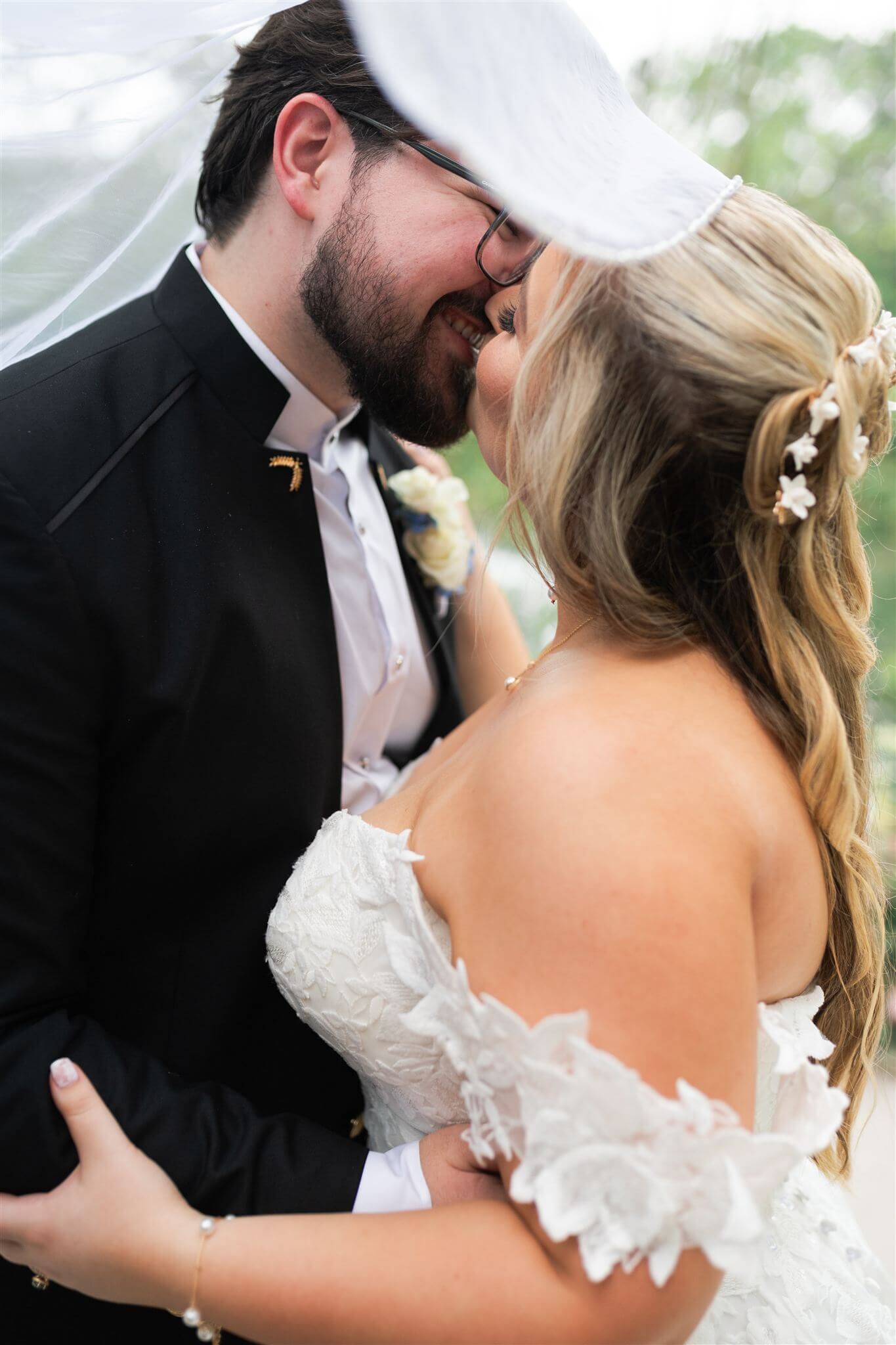 A veil surrounding a couple as the curvy bride and groom kiss.