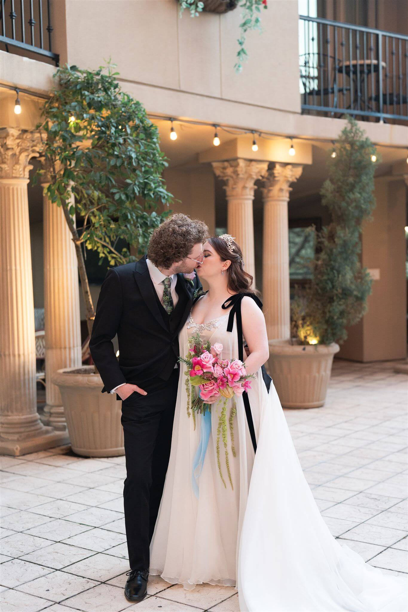 A curvy bride and groom at a 45-degree angle as they share an intimate kiss on their wedding day.