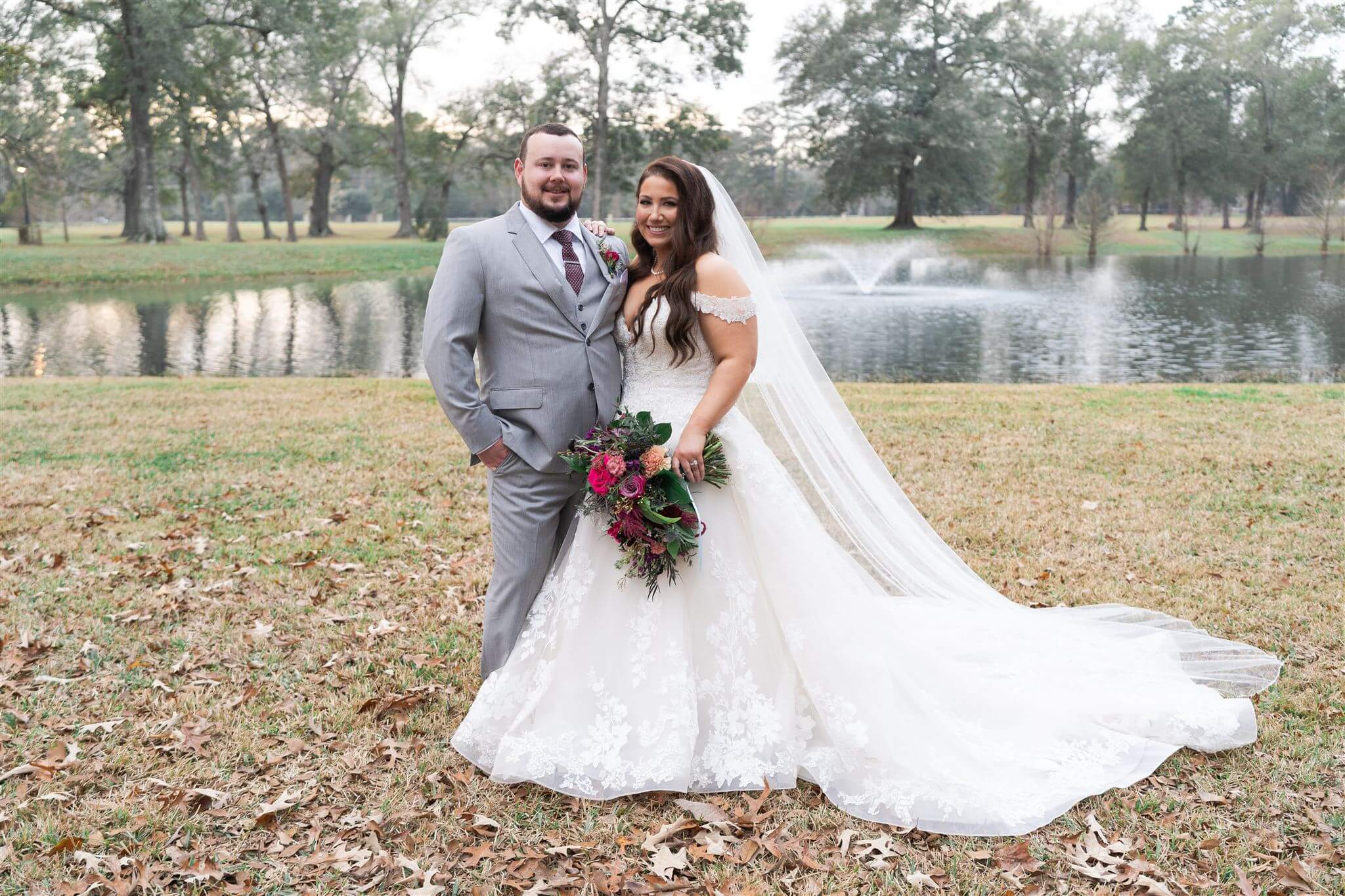 A curvy bride posing with her groom at a 45-degree angle.