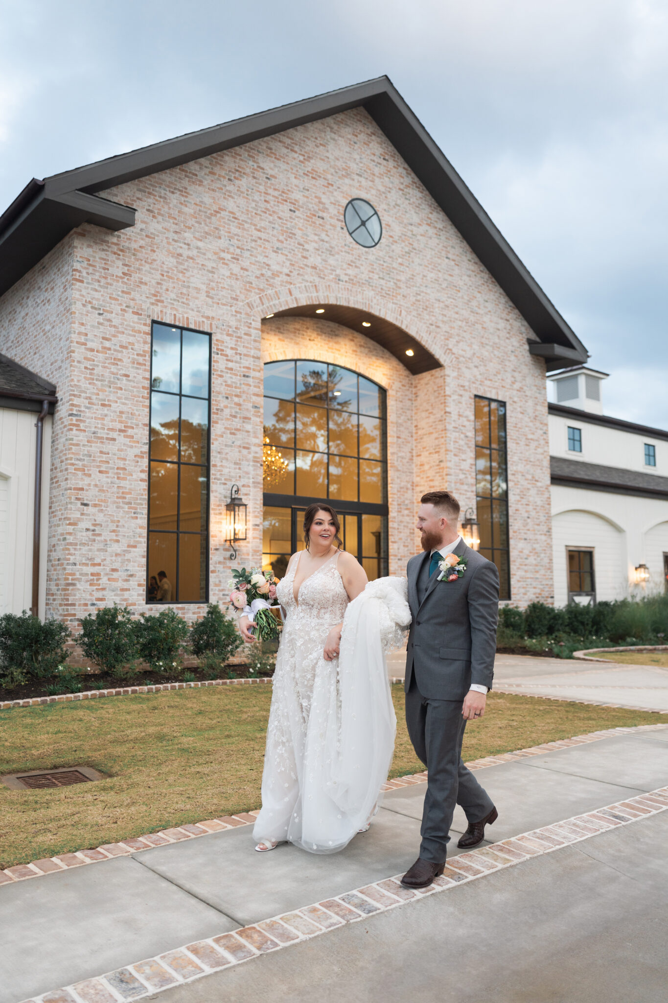 bride and groom walk in front of their wedding venue the Blue Magnolia by Swish and Click Photography